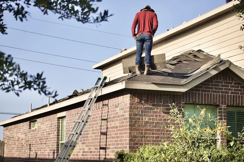 Professional roofer working on a residential roof in Baxter Estates